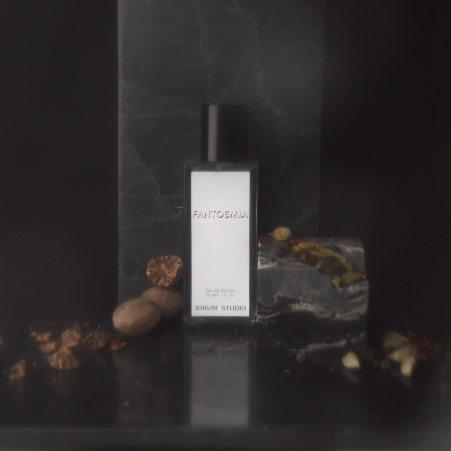 Jorum Studio Fantomia perfume bottle arranged in a still-life with grey marble, nutmeg, saffron and cardamom pods