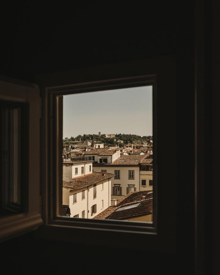 A sunlit view of Florence, Italy from a small window