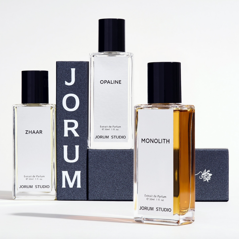 Bottles of Jorum Studio Perfumes Opaline, Monolith and Zhaar piled up alongside grey boxes with JORUM printed on the side