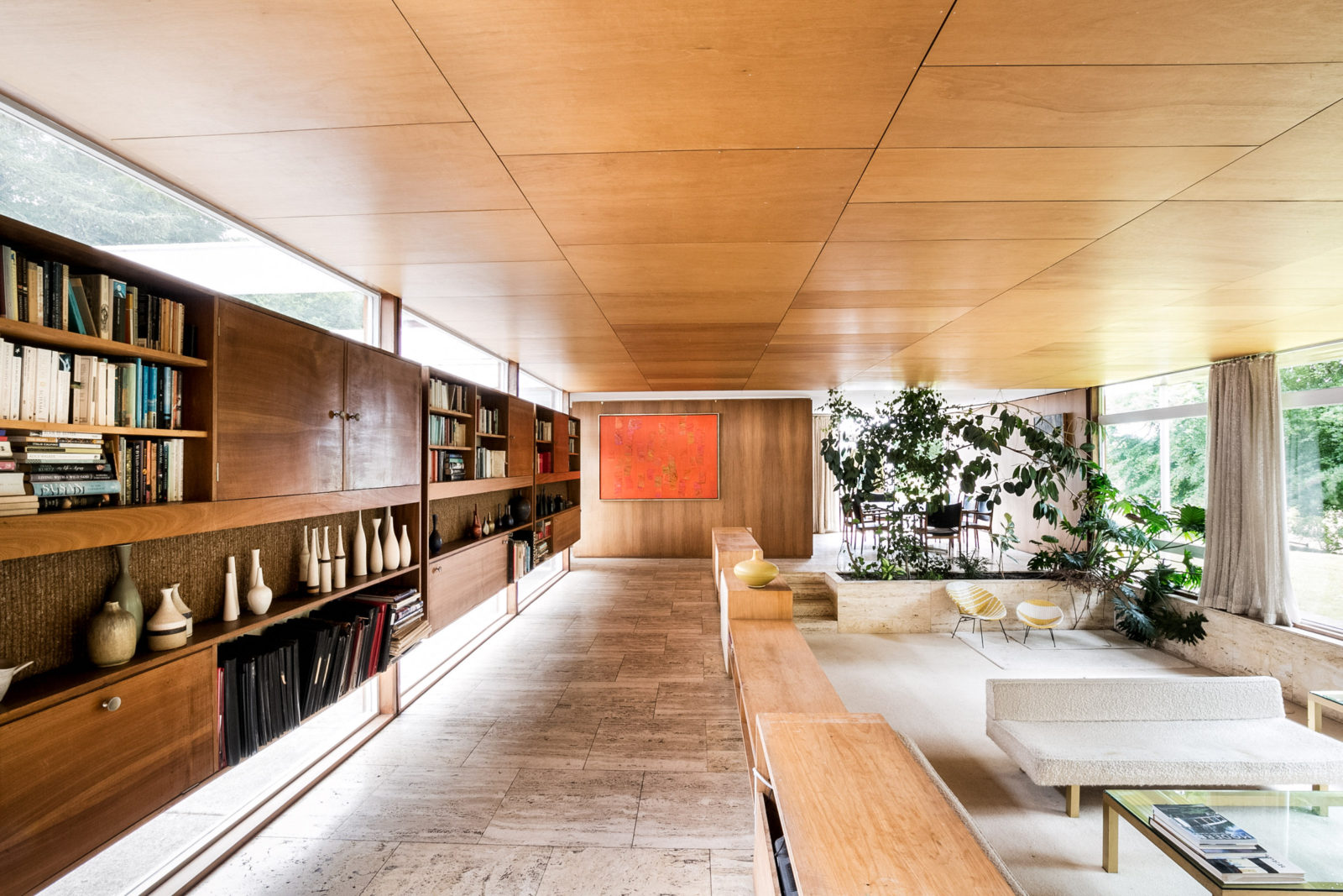 View of the living area of Klein House, with wood panelled ceiling and built in wooden cabinets
