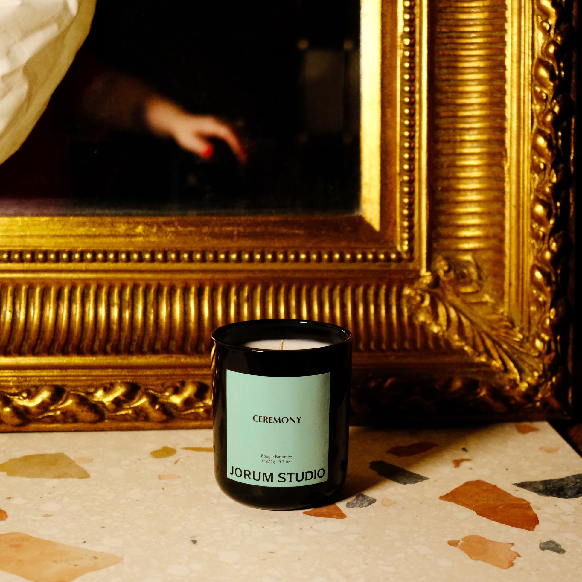 Ceremony candle by Jorum Studio in front of an antique painting in a gilded frame