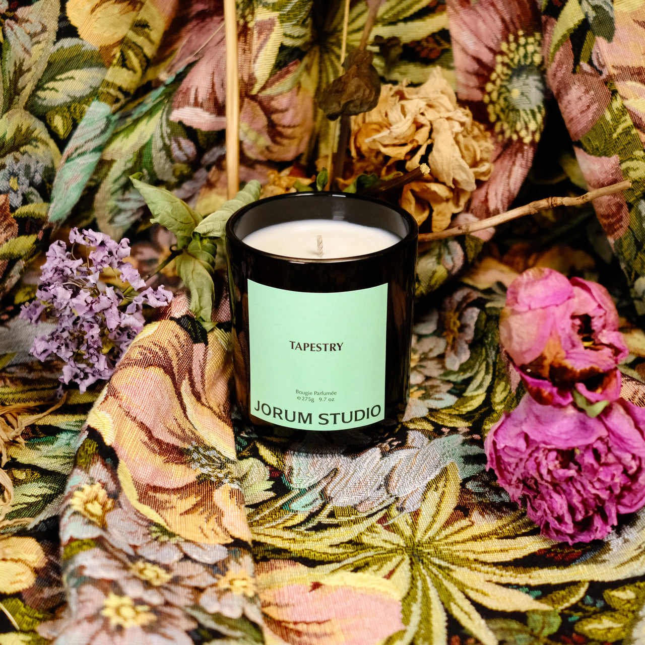 Jorum Studio Tapestry candle on floral brocade fabric with dried flowers